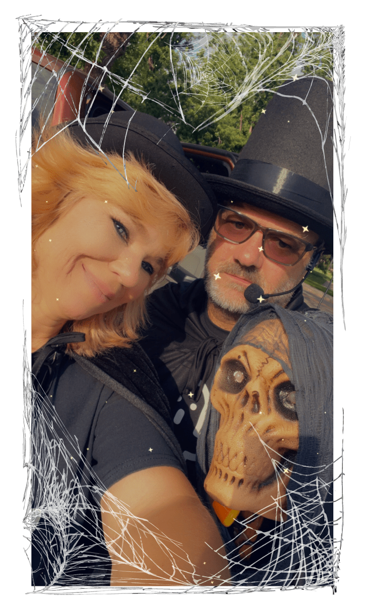 Couple in a witch and wizard costume with a skull wand